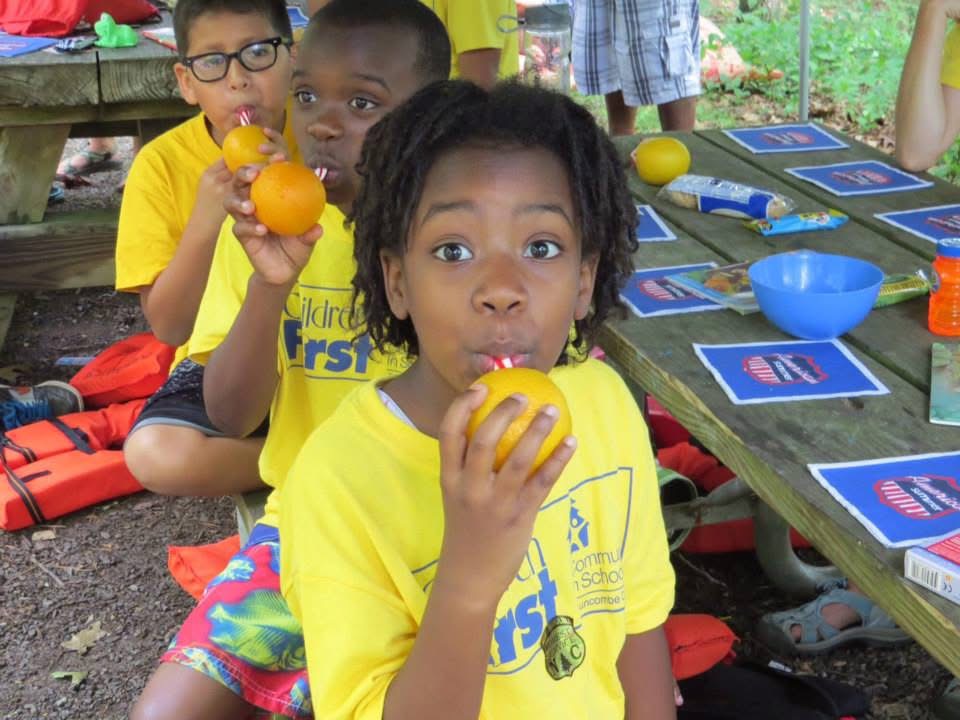 kids drinking from oranges